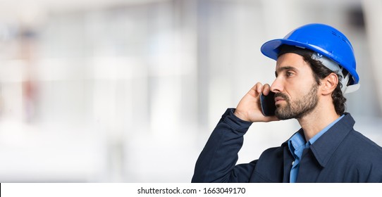Portrait of an handsome engineer using a mobile phone
