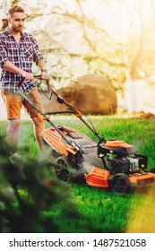 Portrait of handsome gardenere worker using lawnmower and cutting the garden grass - Shutterstock ID 1487521058