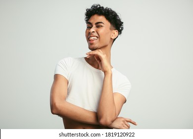 Portrait Of A Handsome Gay Man On White Background. Man Sticking His Tongue Out And Winking At Camera.