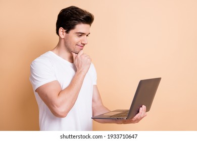 Portrait Of Handsome Guy Hand On Chin Look Interested Laptop Screen Isolated On Beige Color Background