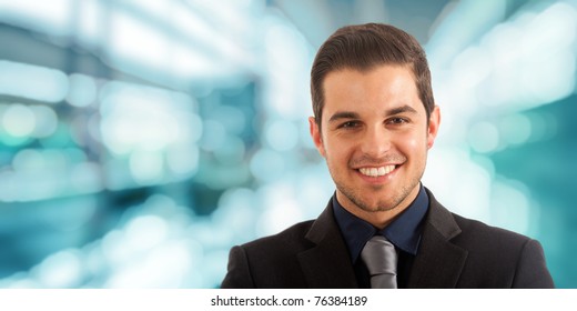 Portrait Of An Handsome Happy Businessman. Blue Blurred Background.