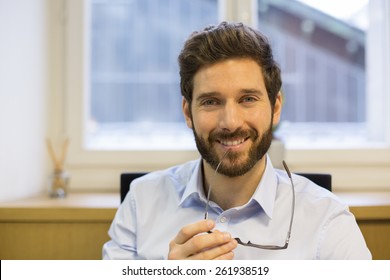 Portrait Of Handsome Hipster Style Bearded Man In Office. Looking Camera