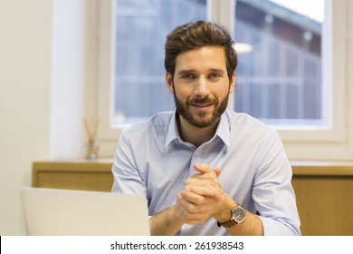 Portrait Of Handsome Hipster Style Bearded Man In Office. Looking Camera