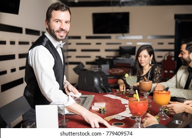 Portrait Of A Handsome Hispanic Card Dealer Playing Blackjack In A Casino