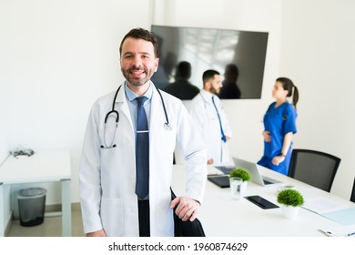 Portrait Of A Handsome Hospital Director In A White Coat And A Stethoscope Smiling Before Starting A Meeting With The Medical Board