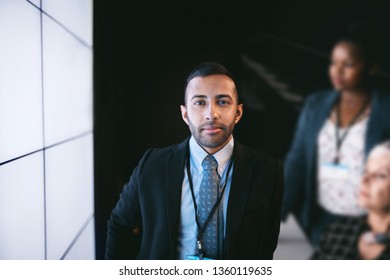 Portrait Of A Handsome Indian, Arabic Businessman Standing Next To A Digital Display Screen In A Dark Boardroom During A Presentation