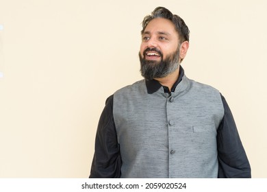 Portrait Of Handsome Indian Businessman Against Plain Background