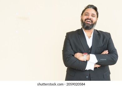 Portrait Of Handsome Indian Businessman Against Plain Background