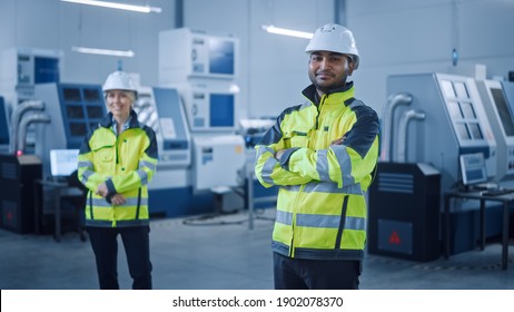 Portrait of Handsome Indian Engineer Wearing Safety Vest and Hardhat Crosses Arms and Smiles. Professional Woman Working in the Modern Manufacturing Factory. Facility with CNC Machinery and robot arm - Powered by Shutterstock