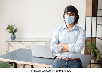 Portrait Of Handsome Indian Man Stands With Arms Crossed In The Office And Looking At The Camera, Wearing A Protective Face Mask During Flu Season Or In Corona Time To Prevent Coronavirus Covid-19