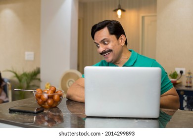 Portrait Of A Handsome Indian Young Man Eating Sweet Gulab Jamun