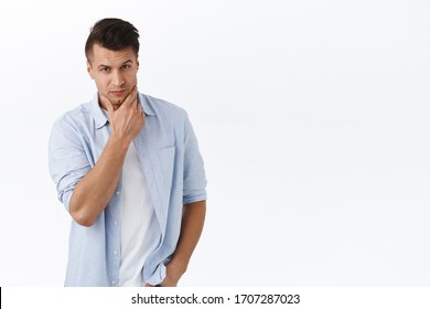 Portrait Of Handsome Macho Man, Stylish Haircut, Touching Clean Shaven Jawline And Looking Thoughtful Camera, Thinking, Consider And Making Choice, Pondering Decision, White Background