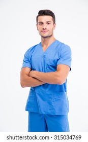 Portrait of a handsome male doctor standing with arms folded isolated on a white background. Lookign at camera