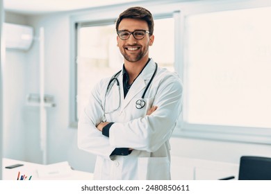 Portrait of handsome male doctor with stethoscope over neck working while looking at camera in the medical consultation. - Powered by Shutterstock