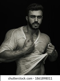 Portrait Of Handsome Male Fitness Model Holding His Wet Tshirt In Sepia Tone