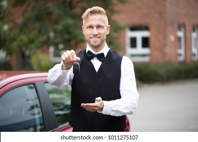 Portrait Of A Handsome Male Valet Holding Car Keys Outdoors