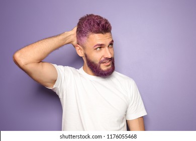 Portrait Of Handsome Man With Dyed Hair And Beard On Color Background