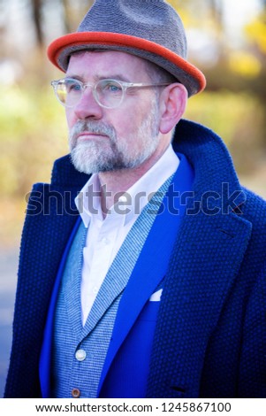 Similar – Man in tails with bouquet and top hat looks into camera