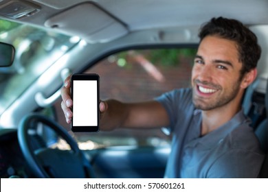 Portrait Of Handsome Man Holding Phone In Car