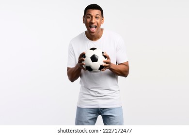 Portrait of handsome man holding soccer ball at his hands with smiling positive expression, wearing white shirt. Indoor studio shot isolated on white background  - Powered by Shutterstock