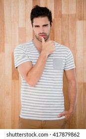 Portrait of handsome man posing in front of wooden background