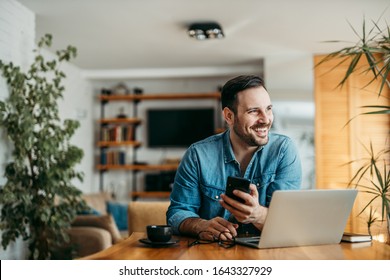 Portrait of a handsome man with smart phone and laptop at home, looking away and smiling. - Shutterstock ID 1643327929