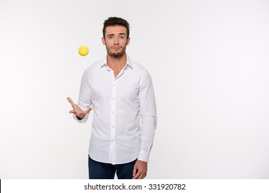 Portrait of a handsome man throwing tennis ball isolated on a white background
