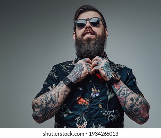 Portrait of a handsome man wearing sunglasses and black shirt in gray background. Cool guy with bearded face and tattoos. - Powered by Shutterstock