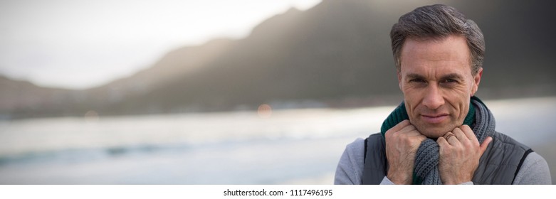 Portrait Of Handsome Mature Man  Against Mountain Against Sky At Beach