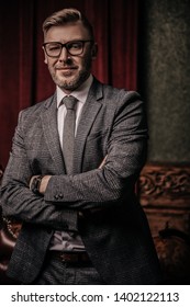A portrait of a handsome mature man in a formal costume posing in the classic interior. Men's beauty, fashion.