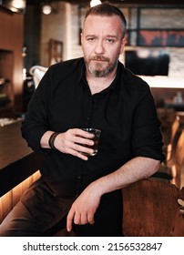 Portrait Of A Handsome Mature Man Holding A Glass Of Neat Whiskey At The Bar Or Pub.