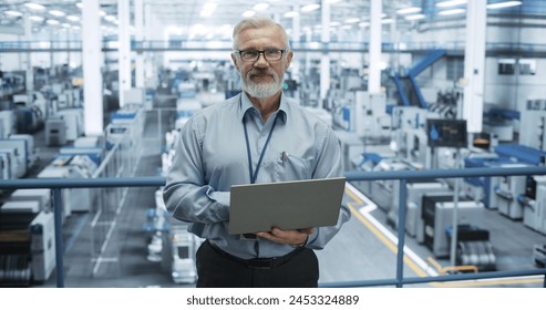 Portrait of a Handsome Middle Aged Engineer Wearing Glasses, Using Laptop Computer and Looking at Camera. Technician in High-VIsibility Vest Working in a Modern Technology Factory - Powered by Shutterstock