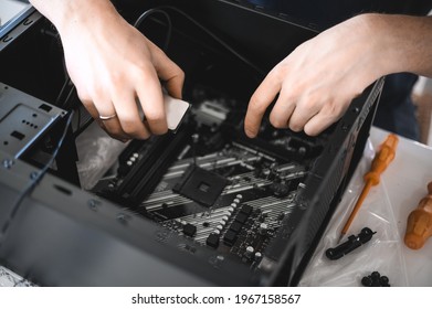 Portrait Of A Handsome Nerd Man Is Servicing Computer Motherboard And Cooler.