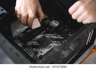 Portrait Of A Handsome Nerd Man Is Servicing Computer Motherboard And Cooler.