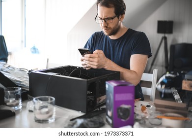 Portrait Of A Handsome Nerd Man Is Servicing Computer Motherboard And Cooler.