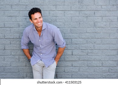 Portrait Of A Handsome Older Man Laughing Against Gray Background