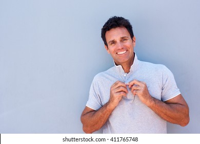 Portrait Of A Handsome Older Man Smiling Against Gray Background