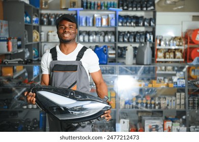 Portrait of a handsome salesman in an auto parts store. The concept of car repair. - Powered by Shutterstock