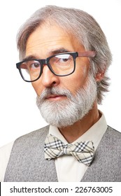 Portrait of handsome senior caucasian man with a gray beard, glasses and bowtie isolated on white background