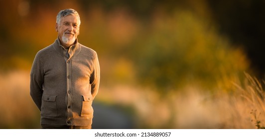 Porträt eines gut aussehenden Senioren im Herbst im Freien. Aktiver Senior, der seinen Ruhestand in der Natur genießt