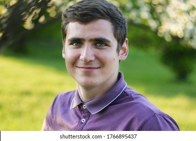 Portrait of handsome serious adult man, student, teenager with short hair on green bokeh background. Caucasian man with light smiling. Businessman. Young startup. Selective focus  