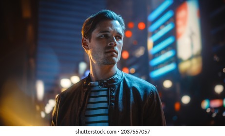 Portrait of Handsome Serious Man Standing, Looking Around Night City with Bokeh Neon Street Lights in Background. Focused Confident Young Man Thinking. Portrait Shot. - Powered by Shutterstock