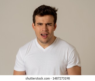 Portrait Of Handsome Shocked Young Man Hearing Unexpected News. Latin Male Looking At Something Shocking With Worried And Surprised Face Making Concern Gestures. Expression And Emotions.