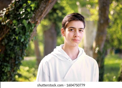 Portrait Of Handsome Shy Teenager Boy In Park Outdoors. Natural Light. Adolescent Boys 