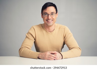 Portrait Of Handsome Smiling Man On A Desk