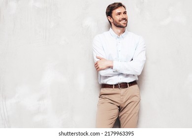 Portrait Of Handsome Smiling Model. Sexy Stylish Man Dressed In Shirt And Trousers. Fashion Hipster Male Posing Near Grey Wall In Studio