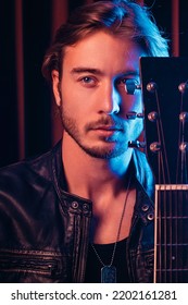 Portrait Of A Handsome Soloist With A Guitar, The Neck Of The Guitar Covers Half Of The Face