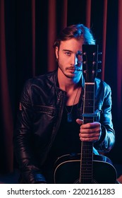 Portrait Of A Handsome Soloist With A Guitar, The Neck Of The Guitar Covers Half Of The Face