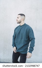 A Portrait Of A Handsome Spanish Man With Buzz Cut Wearing A Blue Sweater Outdoors