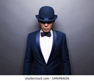 Portrait of handsome stylish man in elegant gray suit and bowler hat.